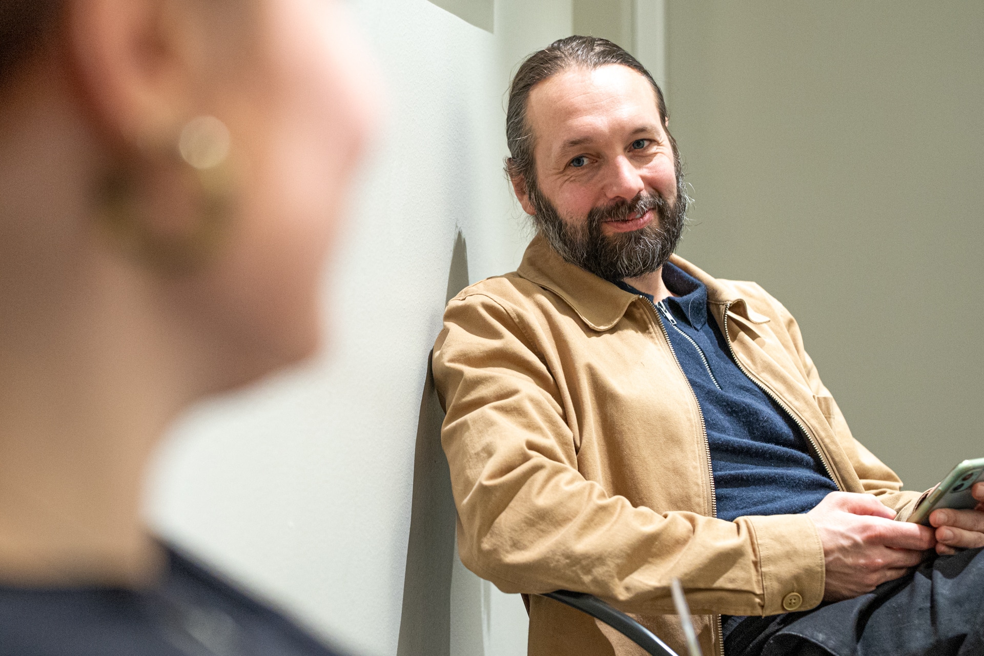 Två frågor som du som chef behöver ställa till dig själv.En man lutar sig mot en vägg och pratar med en kvinna