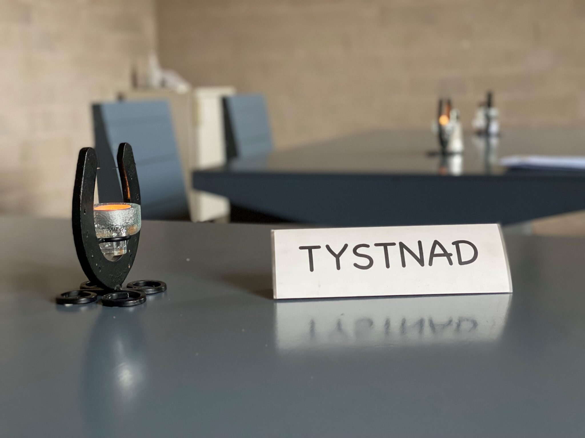 Skylt med ordet Tystnad på ett bord.